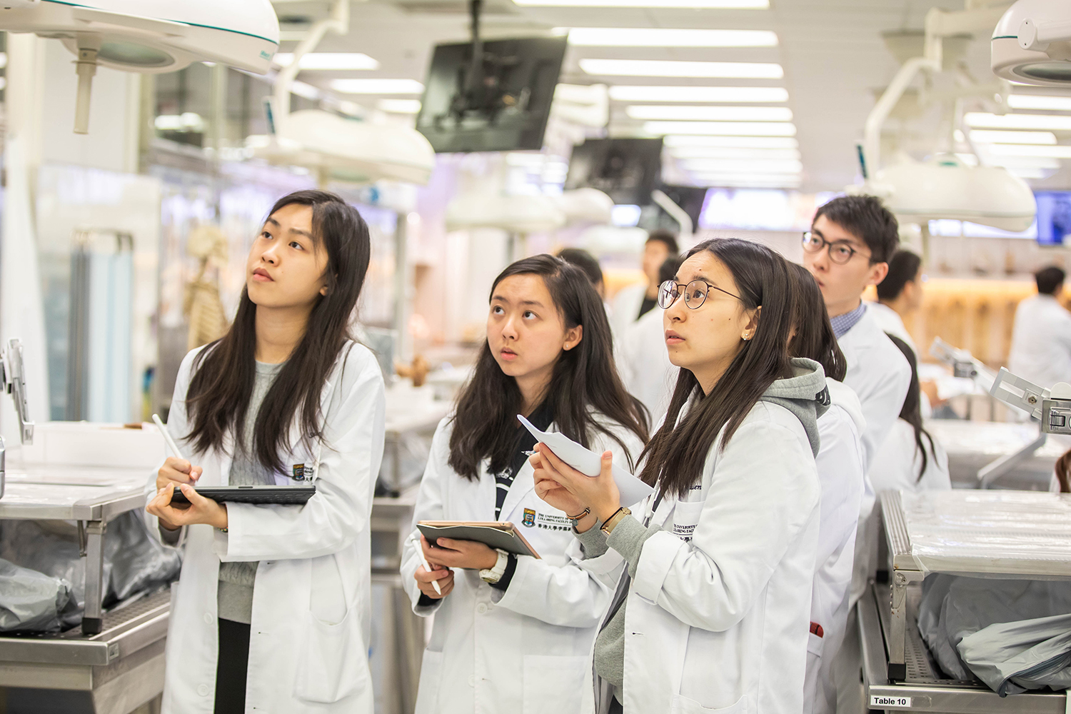 Three students in a class at the anatomy lab.