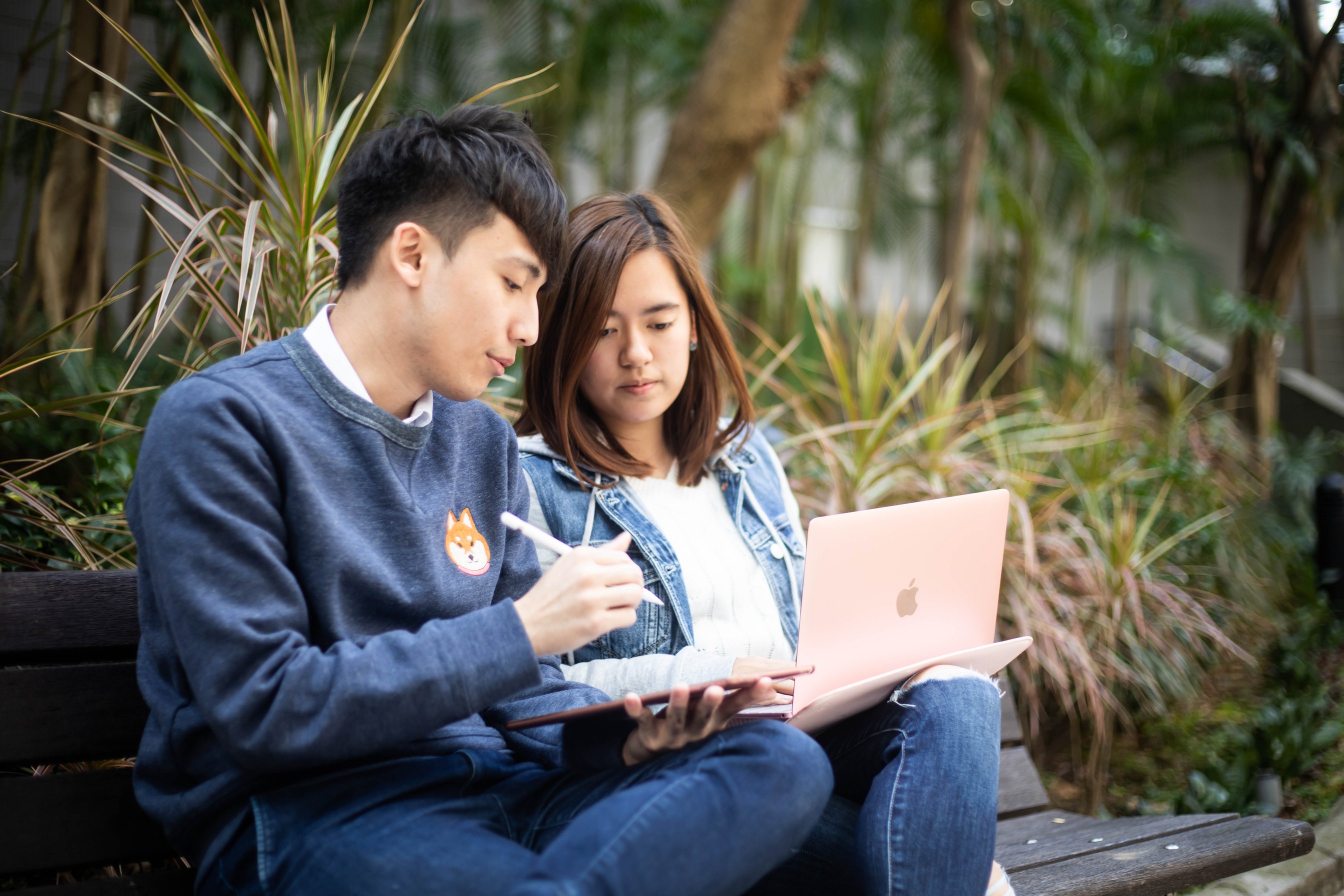 Two students in a discussion on a bench.