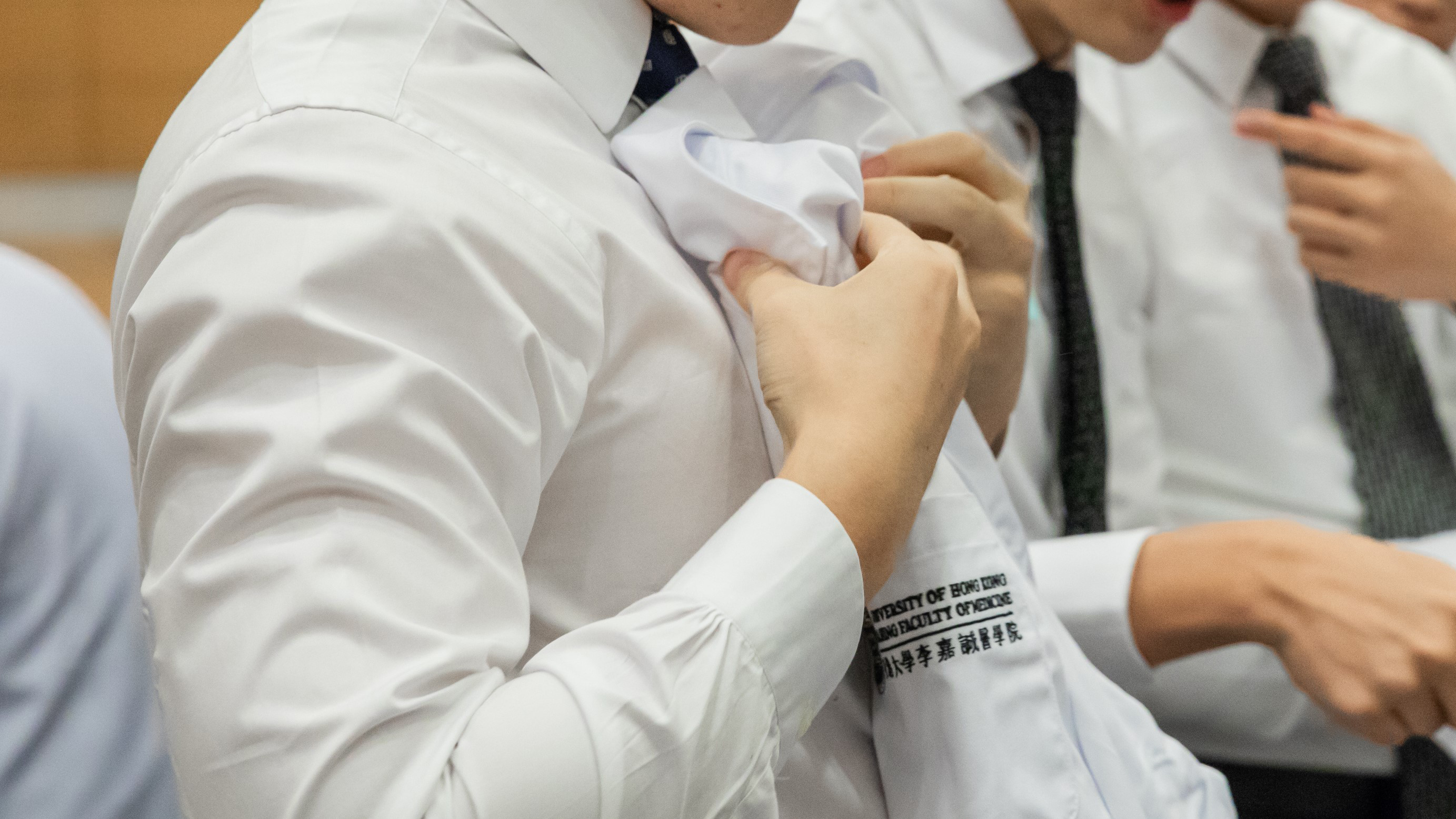 A medical student holding his white coat.